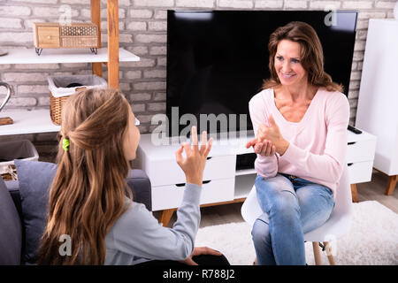 Sorridente donna matura e una ragazza facendo segno lingue a casa Foto Stock