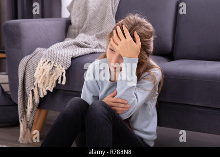 Close-up di un depresso ragazza seduta di fronte divano Foto Stock