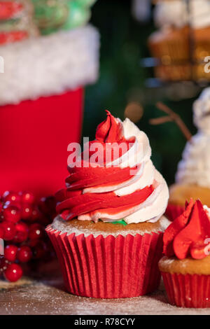 Vari colorati tortini di Natale con albero di natale e uno sfondo di legno Foto Stock