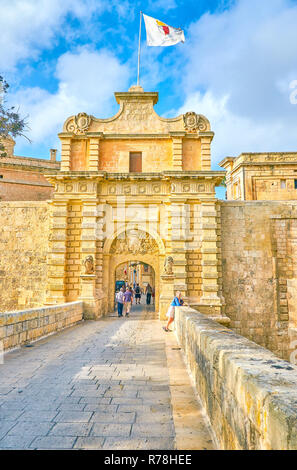 MDINA, Malta - 14 giugno 2018: la passeggiata lungo il medievale Ponte di pietra per la Mdina cancelli, l'ingresso principale alla cittadella city, il 14 giugno in Mdina. Foto Stock