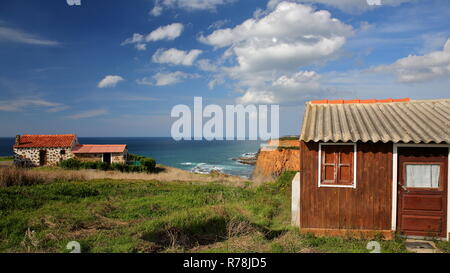 Pescatore colorato capanne sul Alentejo West Coast con scogliere a picco sul mare in background, Porto das Barcas, Zambujeira do Mar, Alentejo, Portogallo Foto Stock