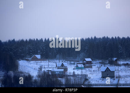 Abbandonata vecchia capanna in legno vicino alla foresta nella soleggiata giornata invernale nel piccolo villaggio di Smolensk Regione della Russia Foto Stock