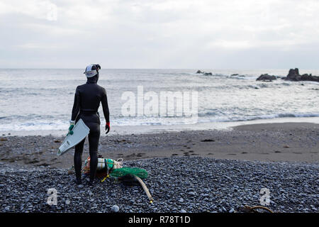 Ama sub in piedi su una spiaggia di ciottoli, la preparazione per le immersioni, Mie, Giappone Foto Stock