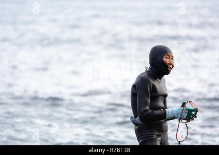 Ama sub in piedi su una spiaggia di ciottoli, la preparazione per le immersioni, Mie, Giappone Foto Stock