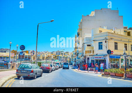 BUGIBBA, Malta - 14 giugno 2018: a piedi lungo la passeggiata a mare e strade nel cuore turistico del resort è il modo migliore per esplorare le offerte di souven Foto Stock