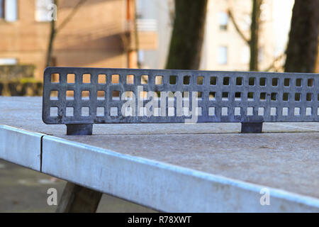 In rovina abbandonato vecchio tavolo da ping pong nel cortile con il focus dell'apertura sulla rete Foto Stock