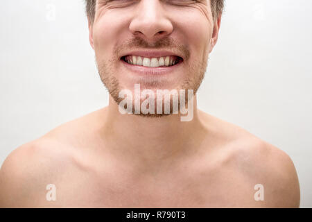 Tagliare virew del giovane uomo sorridente. Egli mostra Denti sani denti bianchi. Isolato su bianco baclground. Close up. Foto Stock