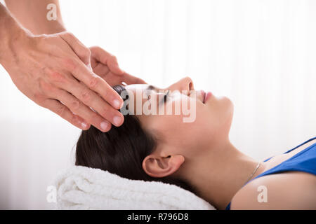 Terapista esegue reiki guarigione trattamento sulla donna Foto Stock