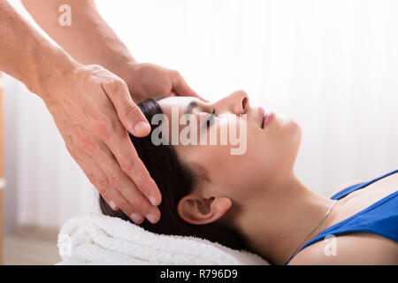 Terapista esegue reiki guarigione trattamento sulla donna Foto Stock