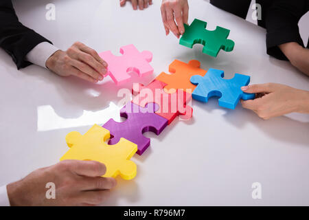 Gruppo di imprenditori risolvendo puzzle Foto Stock