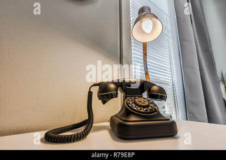 Vecchio telefono retrò e scrivania lampada sul tavolo di legno Foto Stock