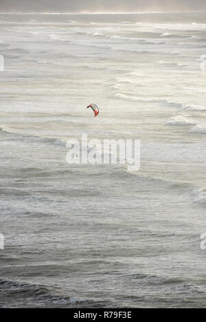 Un Kite surfer in mare mosso e onde della costa del Devon Regno Unito Foto Stock