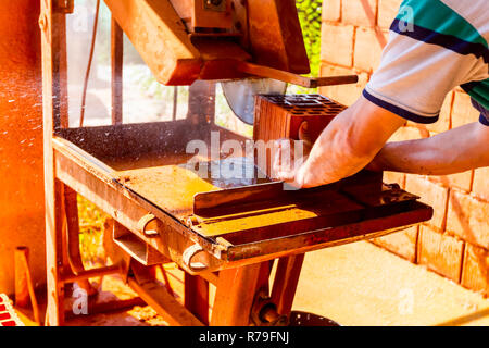 Lavoratore è l'utilizzo di power tool per pulire rende preciso taglio in rosso mattone, blocco. Esso utilizza azione abrasiva per slice attraverso il materiale come la lama ruota a hig Foto Stock