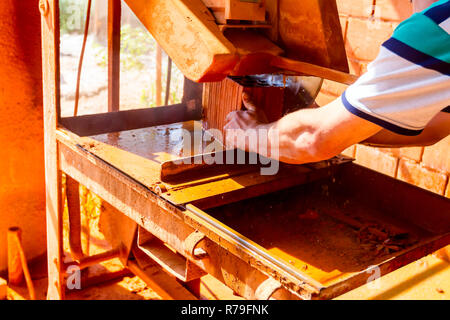 Lavoratore è l'utilizzo di power tool per pulire rende preciso taglio in rosso mattone, blocco. Esso utilizza azione abrasiva per slice attraverso il materiale come la lama ruota a hig Foto Stock