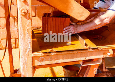 Lavoratore è l'utilizzo di power tool per pulire rende preciso taglio in rosso mattone, blocco. Esso utilizza azione abrasiva per slice attraverso il materiale come la lama ruota a hig Foto Stock