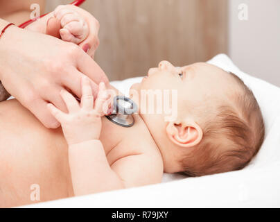 Close-up shot di pediatra esamina due mesi baby boy. Medico utilizzando uno stetoscopio per ascoltare i neonati petto controllo battito del cuore e dei polmoni Foto Stock