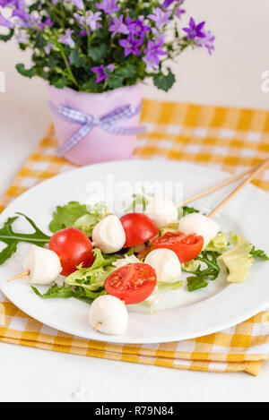 Aperitivo sul bastone con pomodoro e mozzarella. Foto Stock