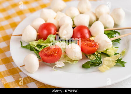 Aperitivo sul bastone con pomodoro e mozzarella. Foto Stock