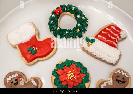 Tradizionali biscotti di Natale con diverse forme: santa hat e boot, ghirlanda di Natale, felice l'uomo... Biscotti fatti in casa con decorazione di festa. Foto Stock