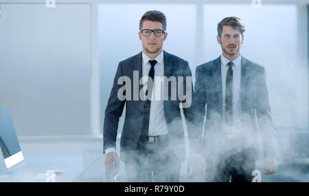 I giovani uomini di affari in un ufficio affumicato Foto Stock
