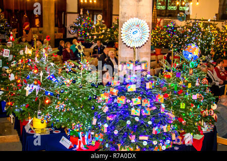 Festival degli alberi di Natale presso la chiesa di San Paolo, Bedford, Regno Unito, con persone ascolto di canti natalizi cantato dal coro Foto Stock