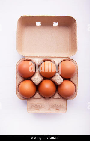 Le uova di gallina in scatola per uova di colore bianco su sfondo di legno. Foto Stock