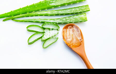 Aloe vera affettato isolato su marrone cucchiaio di legno su sfondo bianco. Foto Stock