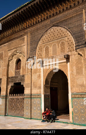 Il Marocco, Fes, Fes el Bali, Medina, Talaa Seghira, Medersa Bou Inania, giovani turisti sat in porta Foto Stock