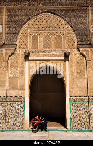 Il Marocco, Fes, Fes el Bali, Medina, Talaa Seghira, Medersa Bou Inania, giovani turisti sat in porta Foto Stock