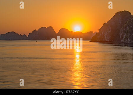 Il sole tocca appena la torreggiante affioramenti rocciosi a Halong Bay Vietnem dalla nostra barca Foto Stock