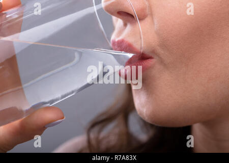 Close-up di una donna assetata di acqua potabile Foto Stock