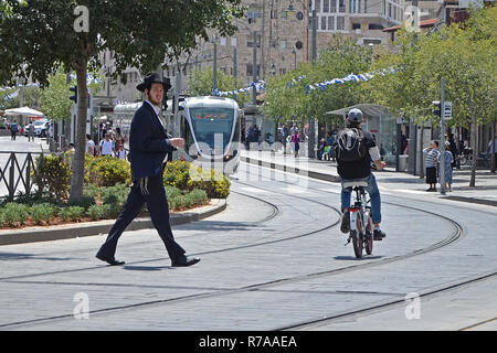 Gerusalemme, Israele - 18/05/2018: un religioso ebreo attraversa la strada su una sede tranviaria. La violazione delle regole del traffico, dell'incidente. Foto Stock