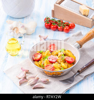 Gnocchi al forno con pesto verde,pomodorini e scaglie di parmigiano Foto Stock