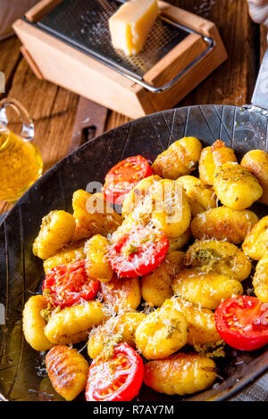 Gnocchi al forno con pesto verde,pomodorini e scaglie di parmigiano Foto Stock