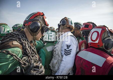 Oceano atlantico (12 aprile 2017) velisti assegnati per il polveroso cani di elicottero di mare squadrone di combattimento (HSC) 7 huddle insieme per celebrare dopo il completamento di un fly-off evoluzione sul ponte di volo della portaerei USS Dwight D. Eisenhower CVN (69) (IKE). Ike e la sua portante strike gruppo sono in corso partecipano in un esercizio di supporto progettati per mantenere la disponibilità di distribuzione come parte della flotta ottimizzato il piano di risposta (OFRP). Foto Stock