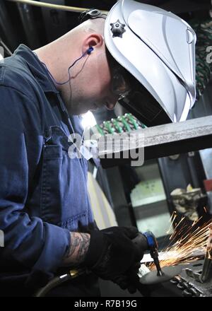 YOKOSUKA, Giappone (11 aprile 2017) - scafo tecnico di manutenzione Fireman Tristian E. Daugherty, da De Soto, Missouri, fissato per gli Stati Uniti 7 ammiraglia della flotta USS Blue Ridge (LCC 19), macina una televisione cavo. Blue Ridge è in un esteso intervallo di manutenzione al fine di modernizzare la nave di continuare a servire come una robusta piattaforma di comunicazione negli Stati Uniti 7 flotta area di operazioni. Foto Stock