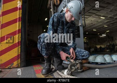 BREMERTON, Washington (8 maggio 2017) Boatswain compagno del 3° di classe Ryan Smith, da Toledo, Ohio, interrompe l'estremità di un filo di contenzione su un rifornimento in corso della stazione di sistemi di puleggia per la manutenzione in USS John C. Stennis' (CVN 74) hangar bay. Le stazioni vengono utilizzati per il tether di navi e di ricevere il carico durante i rifornimenti in corso. John C. Stennis sta conducendo una prevista disponibilità incrementale (PIA) a Puget Sound Naval Shipyard e Manutenzione intermedia Facility, durante il quale la nave sta subendo una manutenzione pianificata e aggiornamenti. Foto Stock