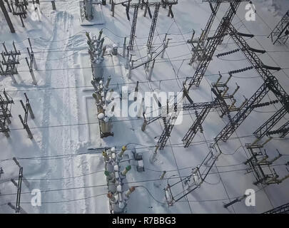 Sottostazione elettrica nella neve in inverno. Fili alta tensione. Foto Stock