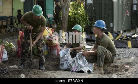 Esercito filippino Cpl. Jovie Jamandron, sinistra, PFC. Tegero benedetto e U.S. Marine Cpl. Quentin Newton riempire sacchi di sabbia durante un'ingegneria civile Progetto di assistenza a sostegno di Balikatan 2017 in Ormoc City, Leyte, 14 maggio 2017. Filippine e di servizio degli Stati Uniti i membri hanno lavorato insieme per costruire nuove aule per gli studenti di Don Carlos di scuola elementare. Balikatan è un annuale U.S.-Philippine bilaterale di esercitazione militare incentrato su una varietà di missioni, comprese la fornitura di assistenza umanitaria e di soccorso in caso di catastrofe, la lotta contro il terrorismo e altri combinati di operazioni militari. Foto Stock