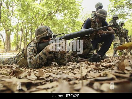 Cpl. Ismael Fonseca, un rifleman con scopi speciali Air-Ground Marine Task Force - Risposta in caso di crisi - Africa, dimostra la posizione prona ad un membro del Senegal di Compagnie Fusilier de Marin Commando a Toubakouta, Senegal, 13 aprile 2017. Marines con SPMAGTF-CR-AF e il COFUMACO condotta a quattro alla settimana di formazione professionale esercizio che includeva il combattimento avanzate tecniche di cottura, una mitragliatrice gamma e un live-fire attacco di plotone di gamma. Foto Stock