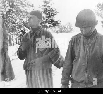 Tahae Sugita (a destra), un soldato Japanese-American con il campo 522nd battaglione di artiglieria, sorge accanto a un campo di concentramento superstite ha appena liberato su una morte marzo da Dachau nel maggio 1945. Foto Stock