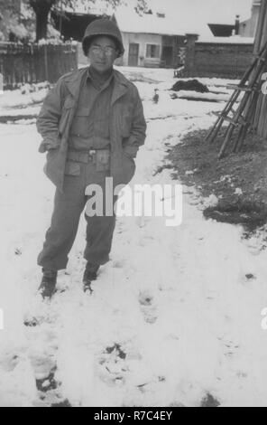 Un soldato Japanese-American con il campo 522nd battaglione di artiglieria pone al di fuori nella neve in Waakirchen, Germania, nel maggio 1945. Foto Stock