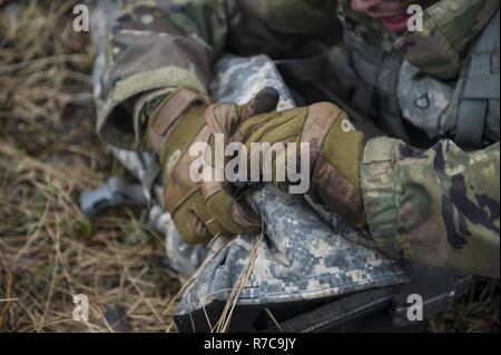 Un U.S. Soldato con il 6° Brigata Battaglione ingegnere (airborne), Base comune Elmendorf Richardson, Alaska, fissa un caso per cavalletto durante il bordo settentrionale 2017 Maggio 09, 2017 a Fort Greely, Alaska. Il treppiede è stata per un M240 machine gun, che è stato utilizzato durante un funzionamento in cui i soldati simulato il recupero di un'isola da forze ostili. Foto Stock