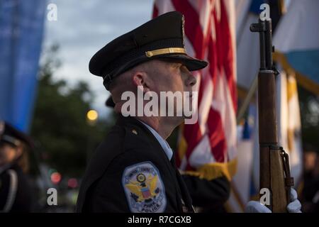 Un membro degli Stati Uniti Park polizia Guardia d'onore presenta bracci durante la cerimonia di apertura della XXIX edizione annuale veglia a lume di candela in onore di caduti gli ufficiali di polizia provenienti da tutto il paese sul National Mall di Washington, 13 maggio 2017. Circa 300 funzionari di polizia dei nomi sono state lette, inciso nel National Police Memorial. Tra questi nomi è stato il personale Sgt. James D. McNaughton, U.S. La riserva di esercito di polizia militare che fu la prima città di New York poliziotto ucciso in azione mentre dispiegato in Iraq, 2 agosto 2005. Foto Stock