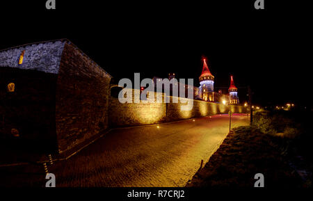 Il castello di Kamianets-Podilskyi illuminato in diversi colori di notte Foto Stock