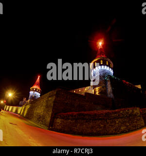 Il castello di Kamianets-Podilskyi illuminato in diversi colori di notte Foto Stock