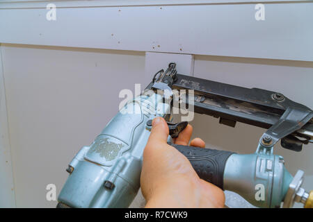 Carpenter brad mediante pistola sparachiodi rivestimento di stampaggio, con tutti gli strumenti di potenza Foto Stock