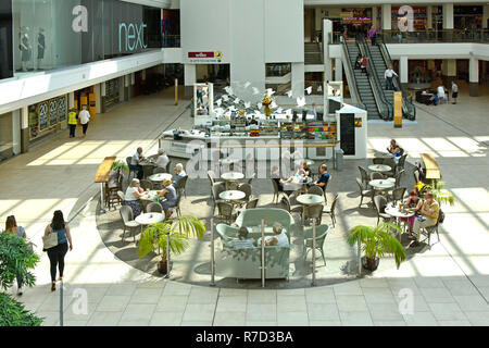 Guardando verso il basso a partire da sopra gli amanti dello shopping nel centro commerciale Mall & persone sedute al cafe tabelle accanto al prossimo negozio di abbigliamento al di là di escalator Southend Essex REGNO UNITO Foto Stock