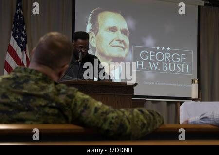 Stati Uniti Il cappellano dell'esercito (Capt.) Dilio Onyejiuwa, un cappellano assegnato alla zona del Mar Nero del Team di Supporto Assistenza Religiosa Team, legge ex presidente George H.W. Bush per la biografia durante un George H.W. Bush memoriale di servizio a Mihail Kogalniceanu Air Base, Romania, Dicembre 5, 2018. Degli Stati Uniti e del Canada e i membri del servizio si sono riuniti per celebrare la memoria di ex presidente George H.W. Bush durante un servizio religioso. Foto Stock