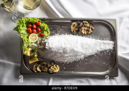 Parte superiore di vista tradizionale italiana o mediterraneean pesce arrostito in sale di mare. Foto Stock